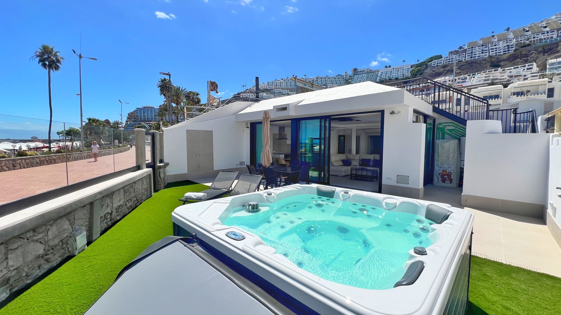 The villa and private jacuzzi under blue skies, steps from the beach